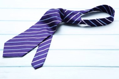 Beyaz ahşap masada çizgili kravat