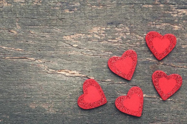 Corazones de purpurina roja sobre mesa de madera gris —  Fotos de Stock