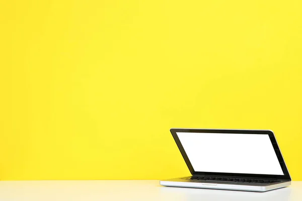 Computador portátil em fundo amarelo — Fotografia de Stock