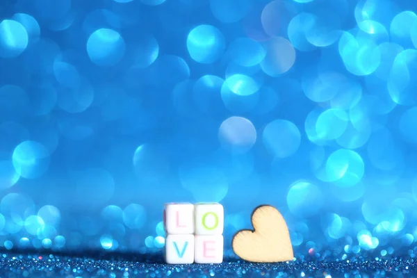 Cuore di legno con la parola Amore su sfondo blu bokeh luci — Foto Stock