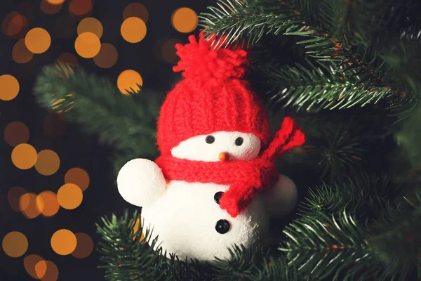 Julgran med liten snögubbe på suddig ljus backgrou — Stockfoto
