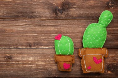Kahverengi ahşap masadaki kaktüslerin farklı yumuşak oyuncakları.