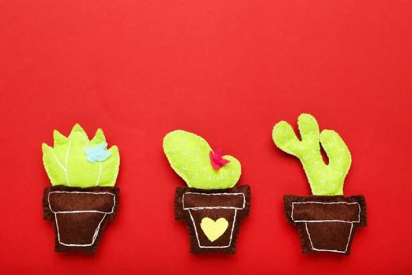 Brinquedo macio diferente de cactos no fundo vermelho — Fotografia de Stock