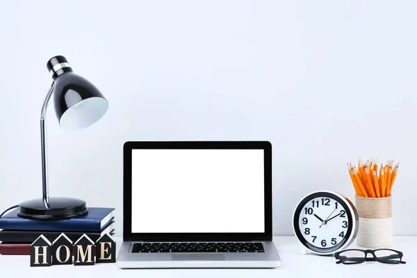 Computador portátil com material de escritório sobre fundo cinzento — Fotografia de Stock