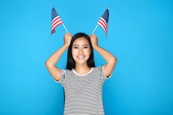 Молодая женщина с американским флагом на синем фоне — стоковое фото