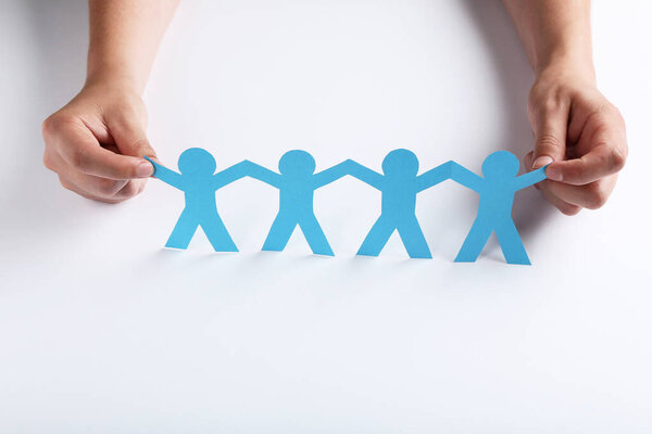 Бумажные цепи людей с женскими руками на белом фоне
