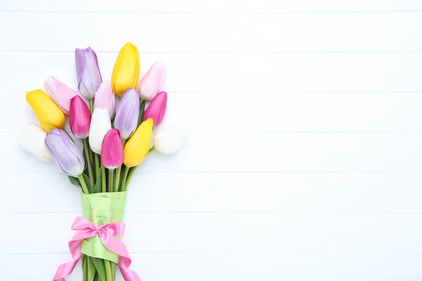 Bukiet kwiatów tulipana ze wstążką na białym drewnianym stole — Zdjęcie stockowe