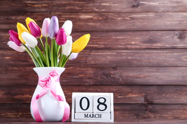 Bouquet di fiori di tulipano in vaso con calendario su b di legno marrone — Foto Stock