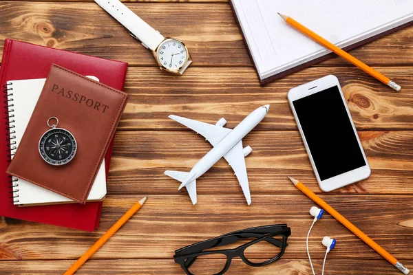 Modelo de avião com passaporte, smartphone, lápis, óculos e — Fotografia de Stock
