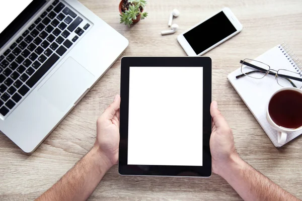 Erkek eller dizüstü bilgisayarı, akıllı telefonu ve c ile tablet bilgisayarı tutuyor.