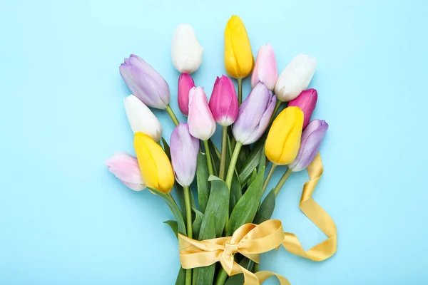 Strauß von Tulpenblumen mit Band auf blauem Hintergrund — Stockfoto