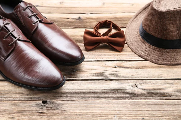 Zapatos de piel masculina con sombrero y pajarita sobre fondo marrón — Foto de Stock