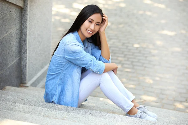 Bella giovane donna seduta sul gradino — Foto Stock