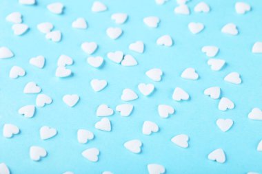 Mavi arka planda kalp şeklinde serpintiler