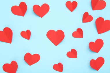 Kırmızı kağıt kalpler mavi arkaplanda