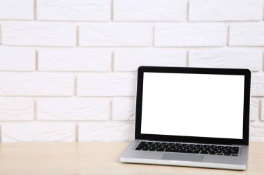 Beyaz tuğla duvar arka planında dizüstü bilgisayar