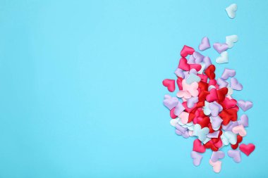 Mavi arkaplanda renkli küçük kalpler