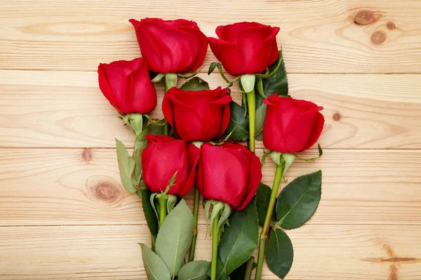 Μπουκέτο Από Κόκκινα Τριαντάφυλλα Καφετί Ξύλινο Τραπέζι — Φωτογραφία Αρχείου