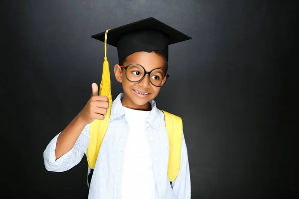 Young African American school boy in graduation cap with backpac — Stock Photo, Image