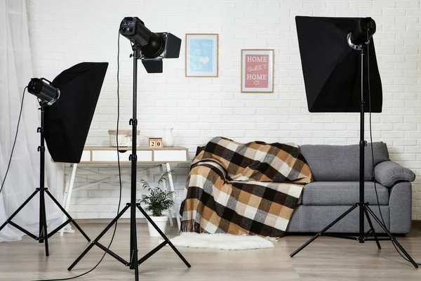 Photo studio with professional equipment and home interior on brick wall background
