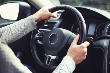 Man holding steering wheel and driving his car clipart