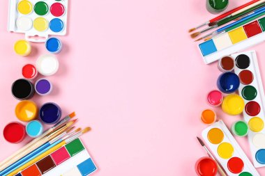 Renkli gouache pembe arka planda boya ve fırçalar