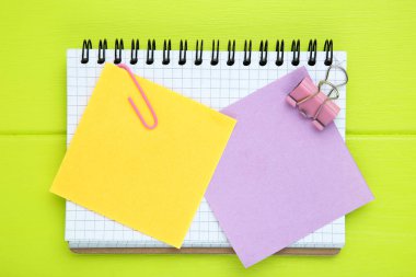 Yeşil ahşap masaya not defteri yapıştırılmış kağıt yapışkan notlar.