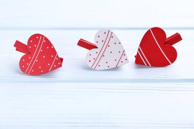 Beyaz ahşap masada mandallı sevgililer günü kalpleri.