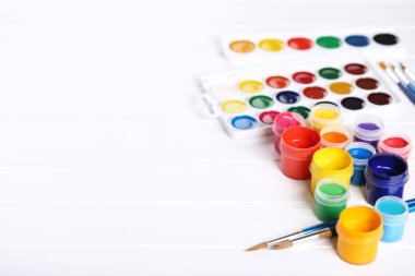 Renkli gouache beyaz ahşap masa üzerinde boya ve fırça