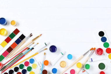 Renkli gouache beyaz ahşap masa üzerinde boya ve fırça