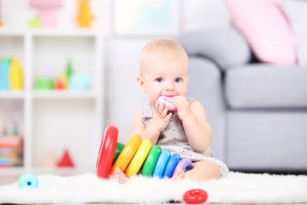 Krásný malý chlapec sedí a hraje si s plastovými hračkami na ho — Stock fotografie