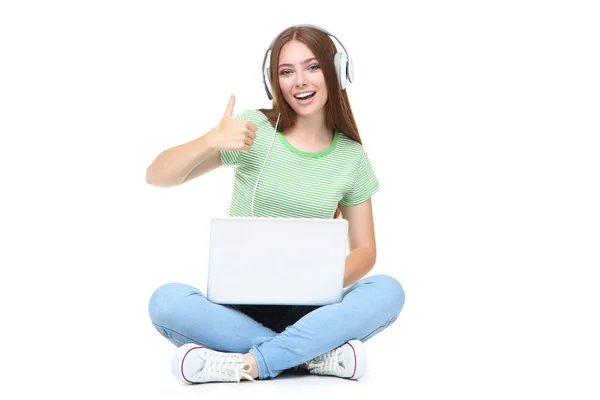 Jonge vrouw in hoofdtelefoon met behulp van laptop computer en tonen thum — Stockfoto