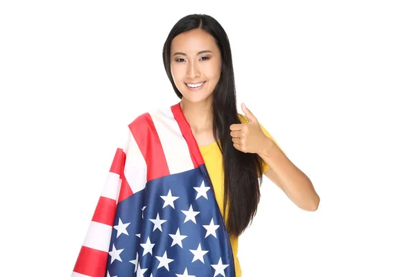 Jonge vrouw verpakt in Amerikaanse vlag en tonen duim omhoog isolat — Stockfoto