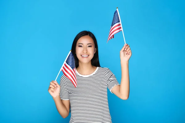 Молодая женщина с американским флагом на синем фоне — стоковое фото