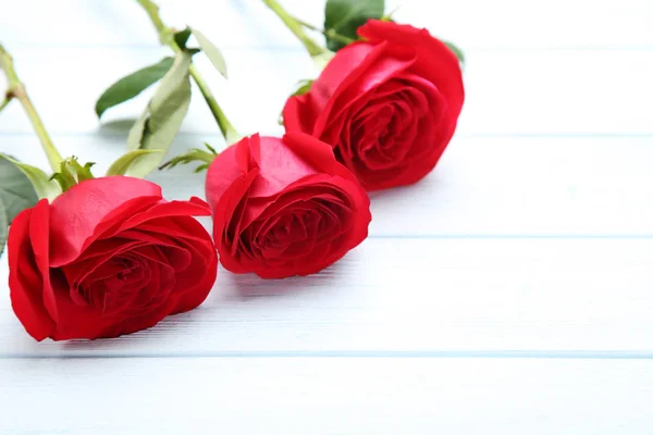 Μπουκέτο Από Κόκκινα Τριαντάφυλλα Λευκό Ξύλινο Τραπέζι — Φωτογραφία Αρχείου