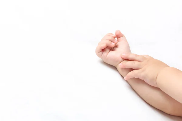 Small baby hands on white bed — Stock Photo, Image