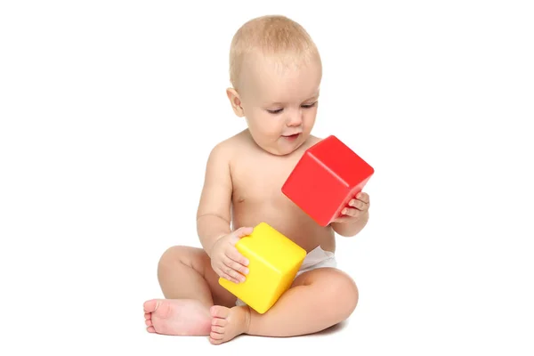 Mooie kleine jongen in luier met plastic kubussen geïsoleerd op wh — Stockfoto