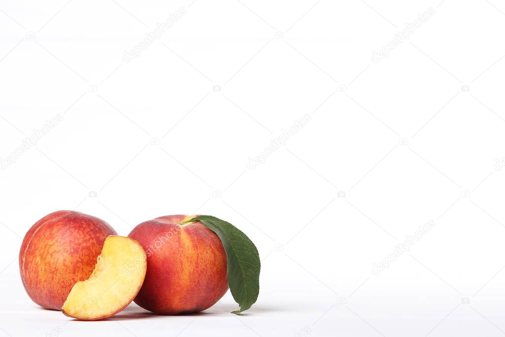 Fresh peaches with green leaf on white background