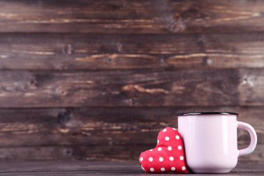 Ahşap masasında kupası olan bir kalp.