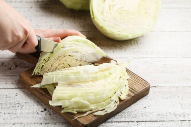 Kadın el kahverengi tahta üzerinde bıçak lahana kesme