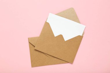 Pembe arka planda kahverengi kağıt zarflar