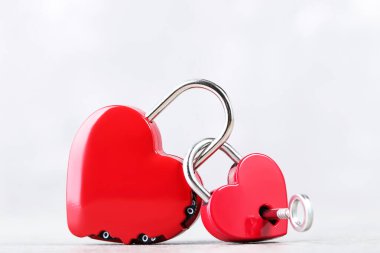 Sevgililer Günü kalp şeklinde asma kilit ve gri arka planda anahtar.