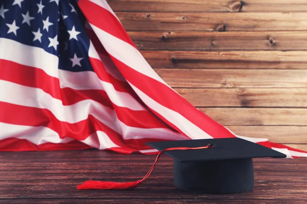Gorra de graduación con bandera americana sobre mesa de madera marrón — Foto de Stock