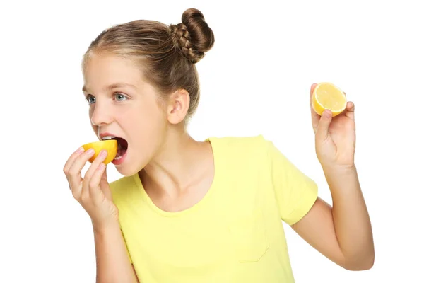 Молода дівчина їсть лимонні фрукти на білому тлі — стокове фото
