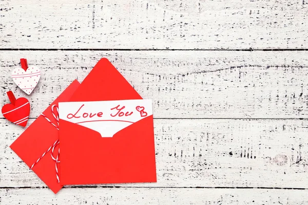 Червоні паперові конверти з сердечками і текстом Люблю тебе на білому вусі — стокове фото