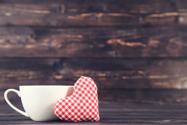 Corazón de tela con copa en mesa de madera —  Fotos de Stock