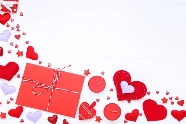 Валентинні серця зі свічками та конвертом на білому дерев'яному столі — стокове фото