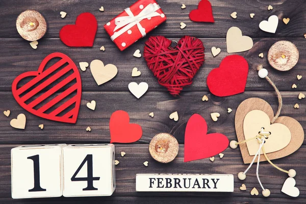 Corazones de San Valentín con calendario de cubos y velas en mesa de madera — Foto de Stock