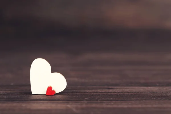 Weiße und rote Herzen auf braunem Holztisch — Stockfoto