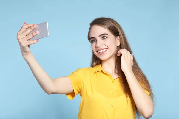 Young beautiful girl making selfie on smartphone — Stock Photo, Image